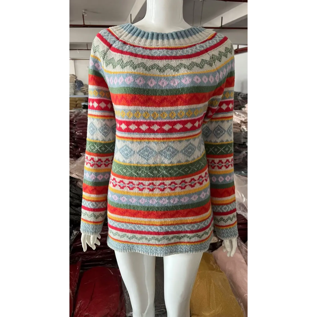 White mannequin front view of fair isle jacquard knit sweater, multicolor horizontal geometric stripes, boat neck, factory storage background
