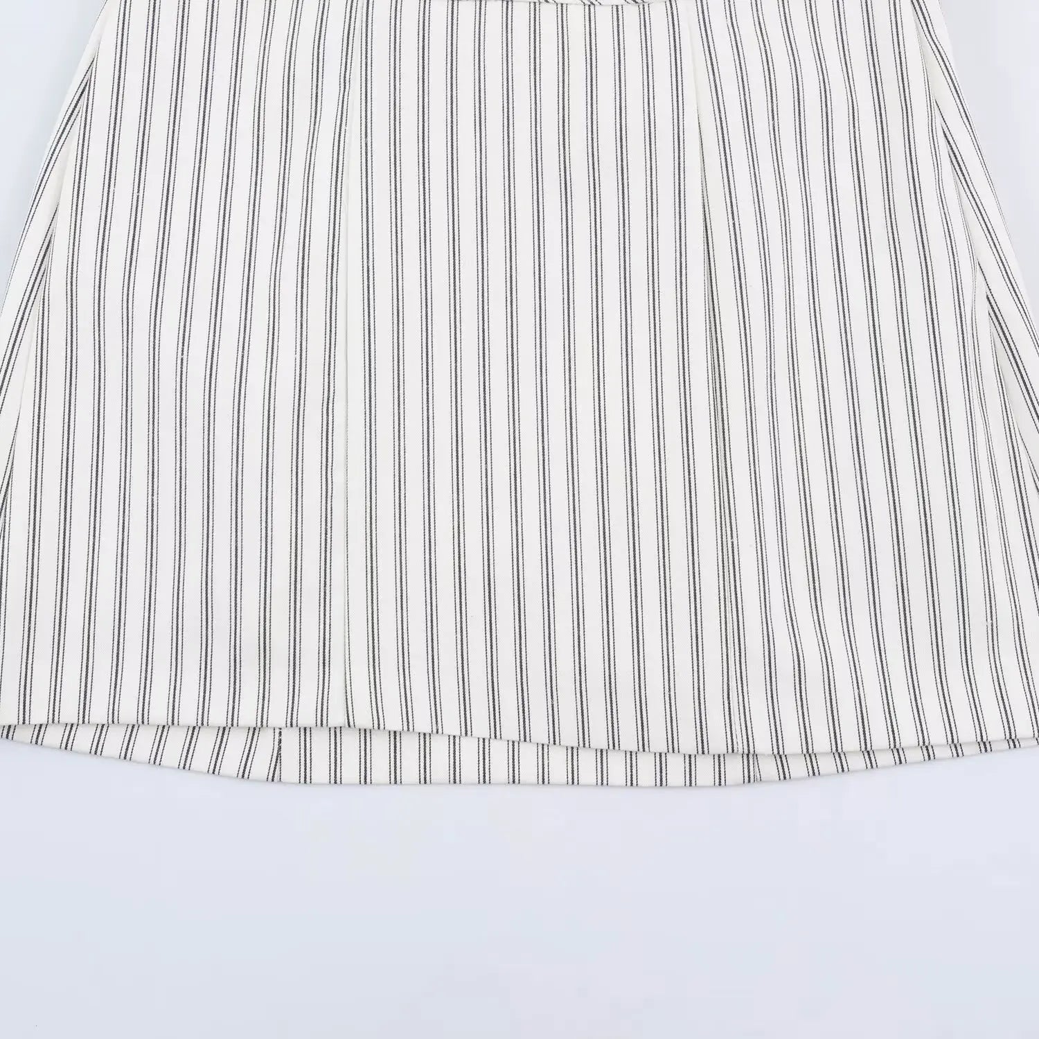 Skirt hem flat overview shot, straight A-line hem, neat serged edge stitching, allover dark vertical stripe print