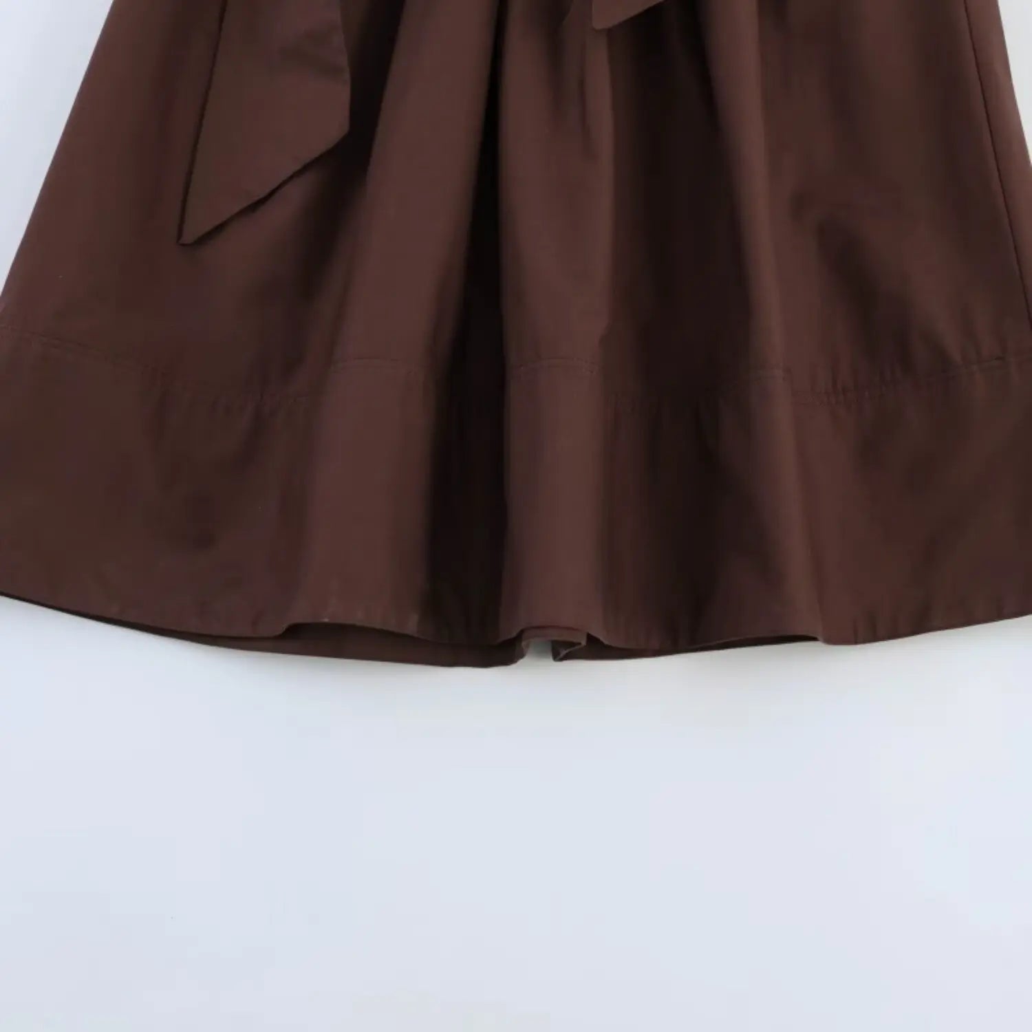 Whole skirt hem partial view, horizontal tier gathering seam, loose swing flared silhouette, even bottom hem binding