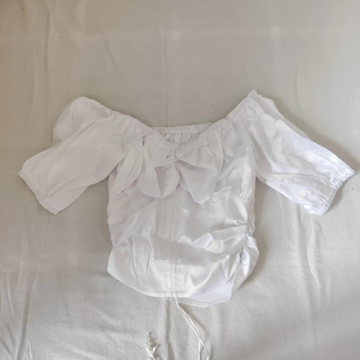 Flat lay front view white off-the-shoulder puff sleeve ruched drawstring cropped blouse