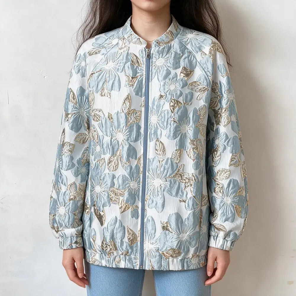 Model wearing floral brocade zip front bomber jacket in light blue, front view