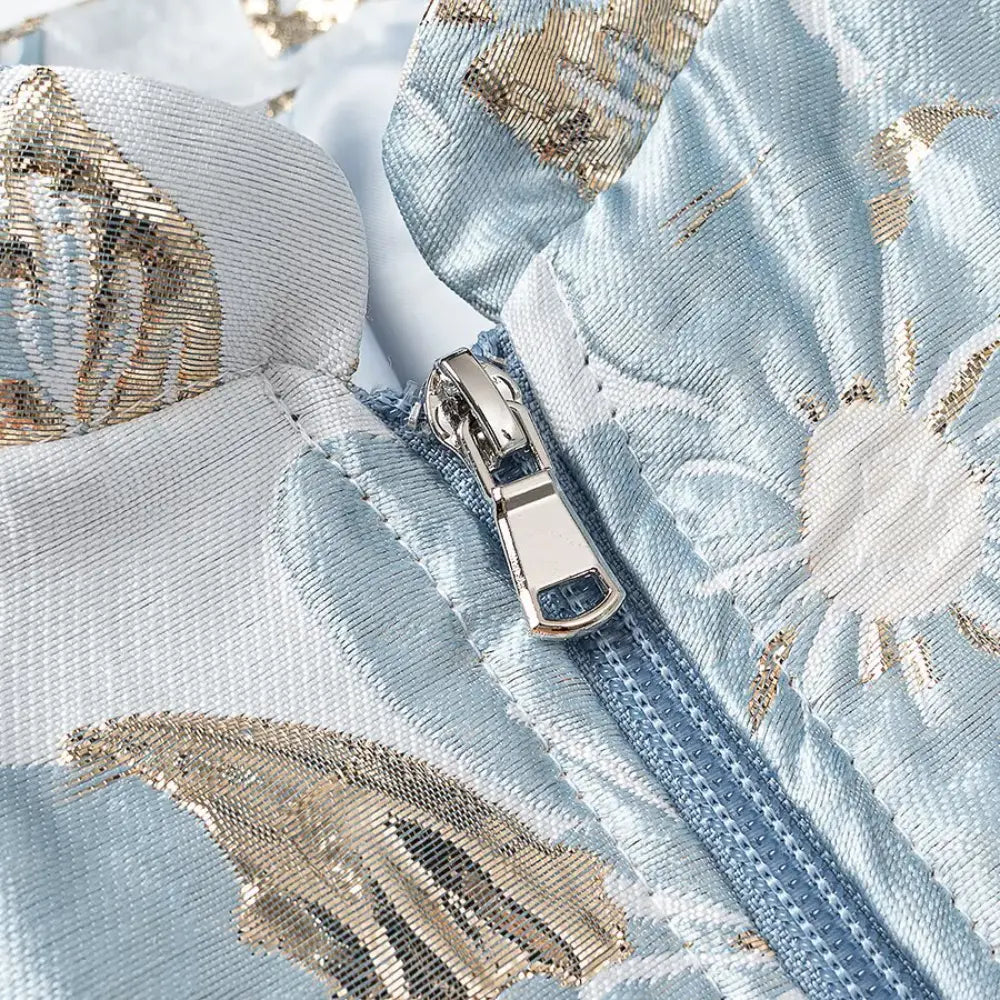 Close-up of metal zipper pull and brocade fabric