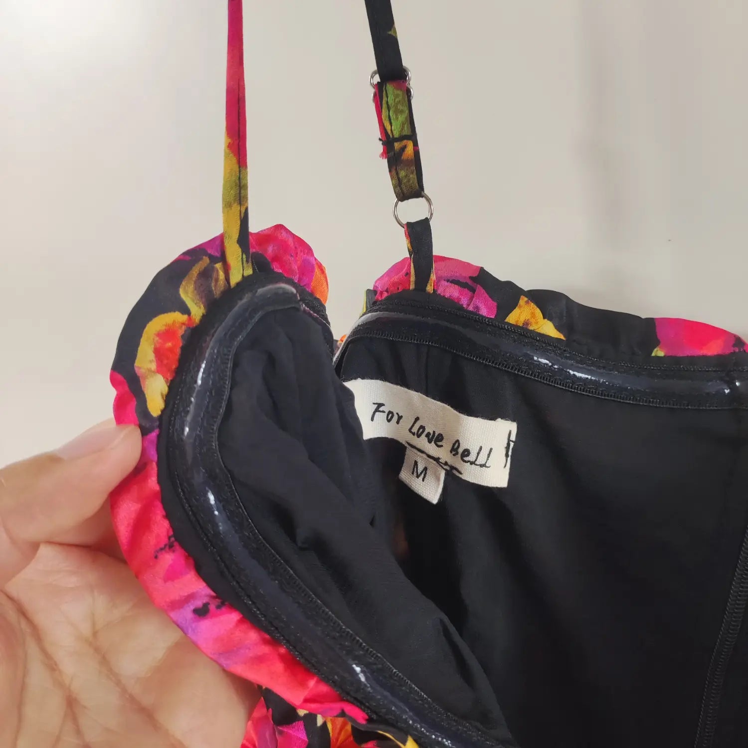 Inner view brand label, adjustable cami strap and silicone grip lining detail floral ruched mini dress