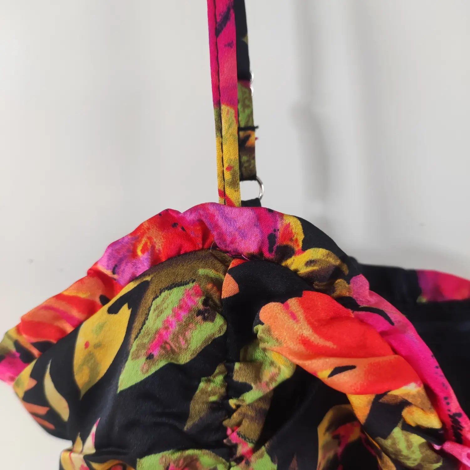 Close‑up shoulder ruffle and printed adjustable cami strap detail black floral ruched mini dress