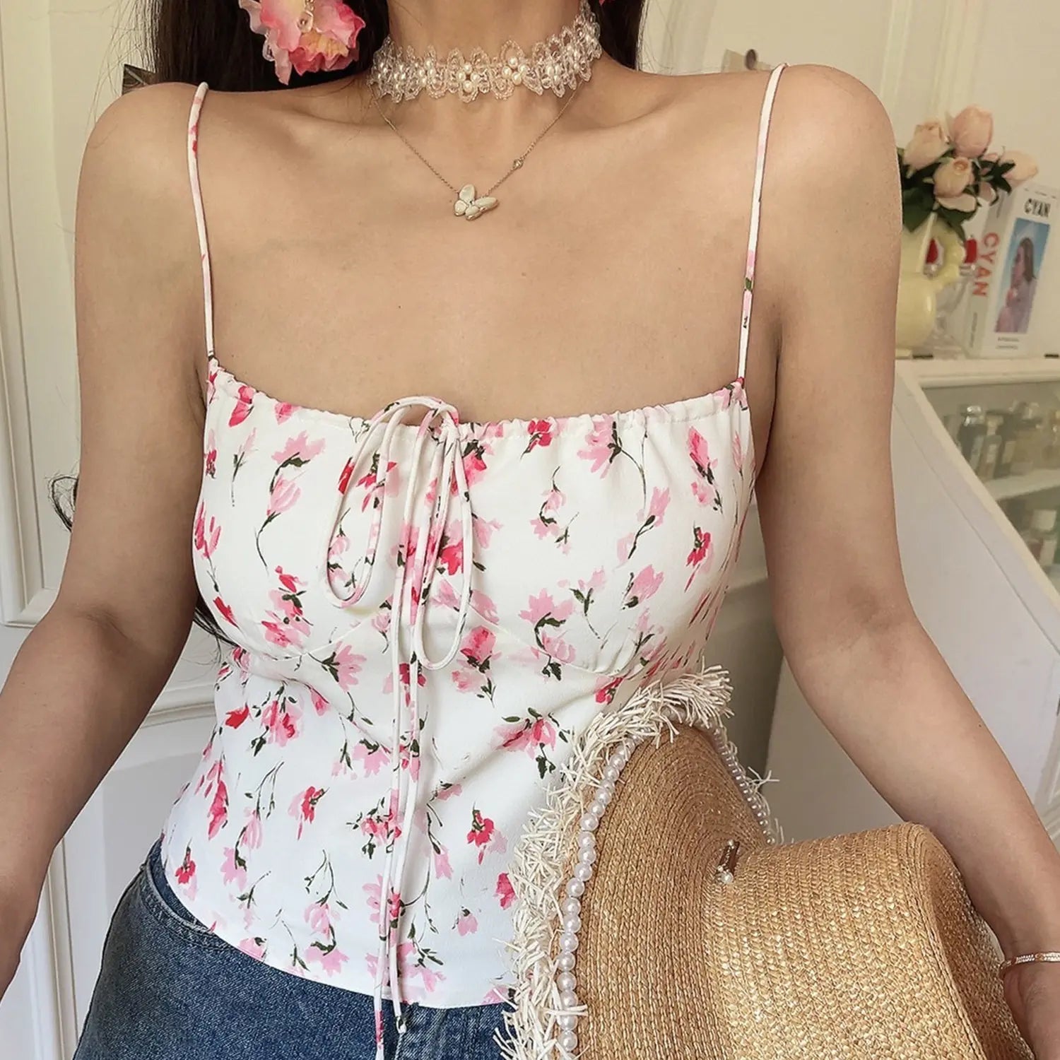 White pink floral drawstring cami top, model holding pearl frayed straw bag, minimalist korean style partial indoor outfit shot