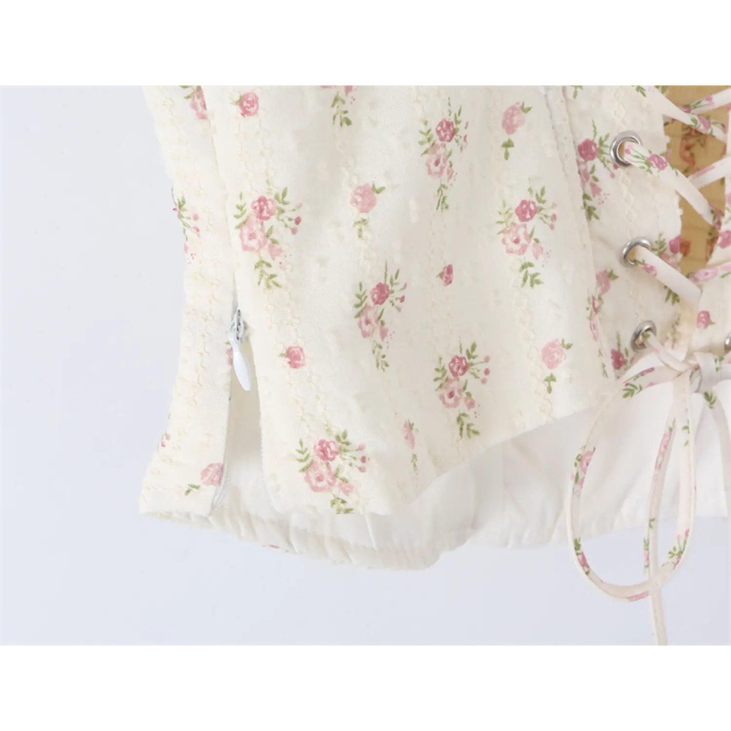 Close-up of the back lace-up closure and side zipper on the floral print corset-style camisole top