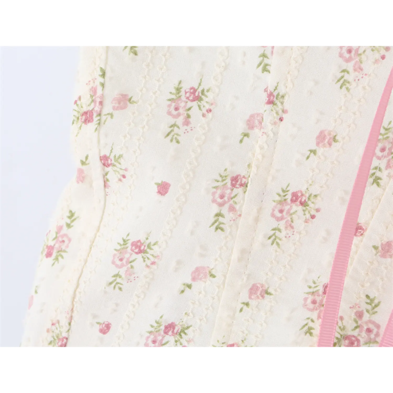 Close-up of the textured fabric with small pink rose print on the corset-style camisole top