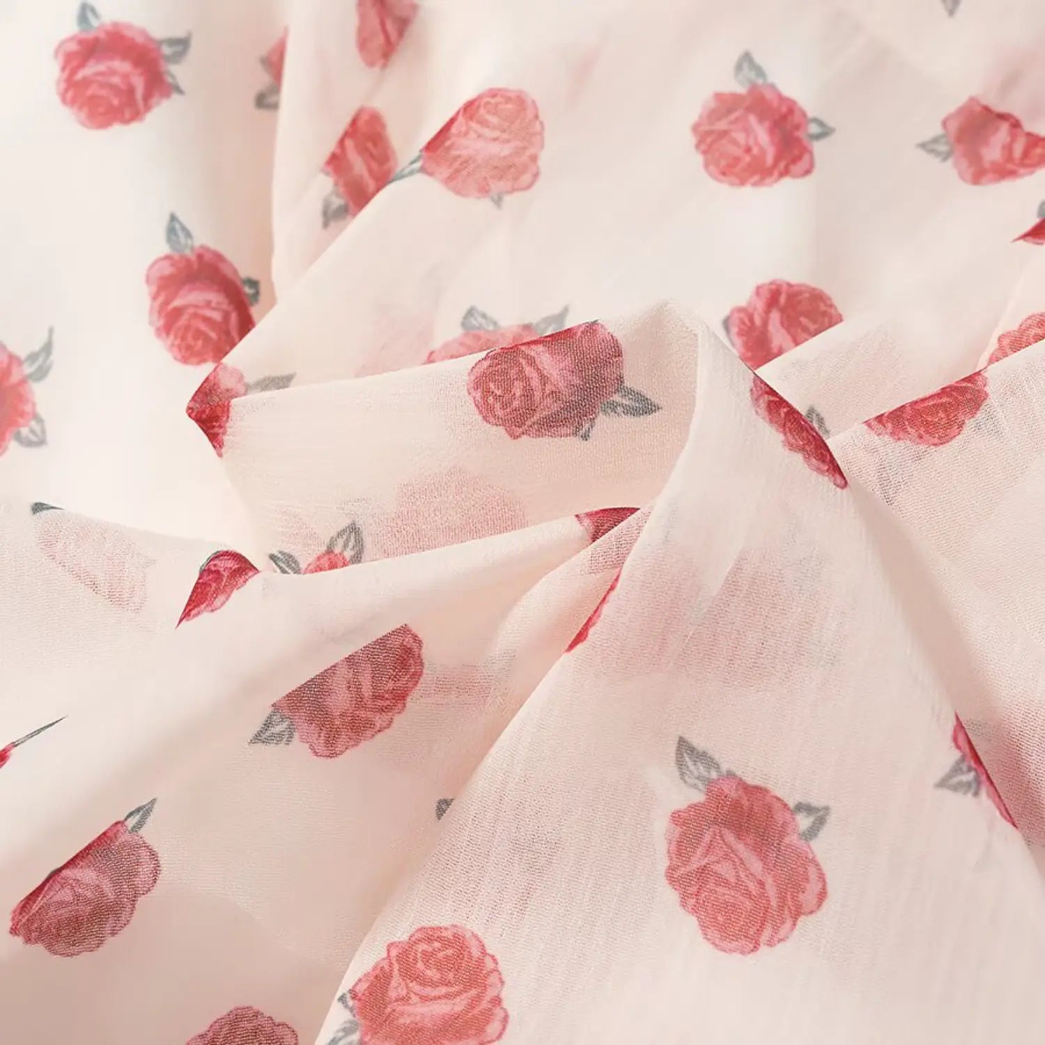 Draped fabric close-up, lightweight sheer crinkle chiffon, scattered mini pink rose watercolor print
