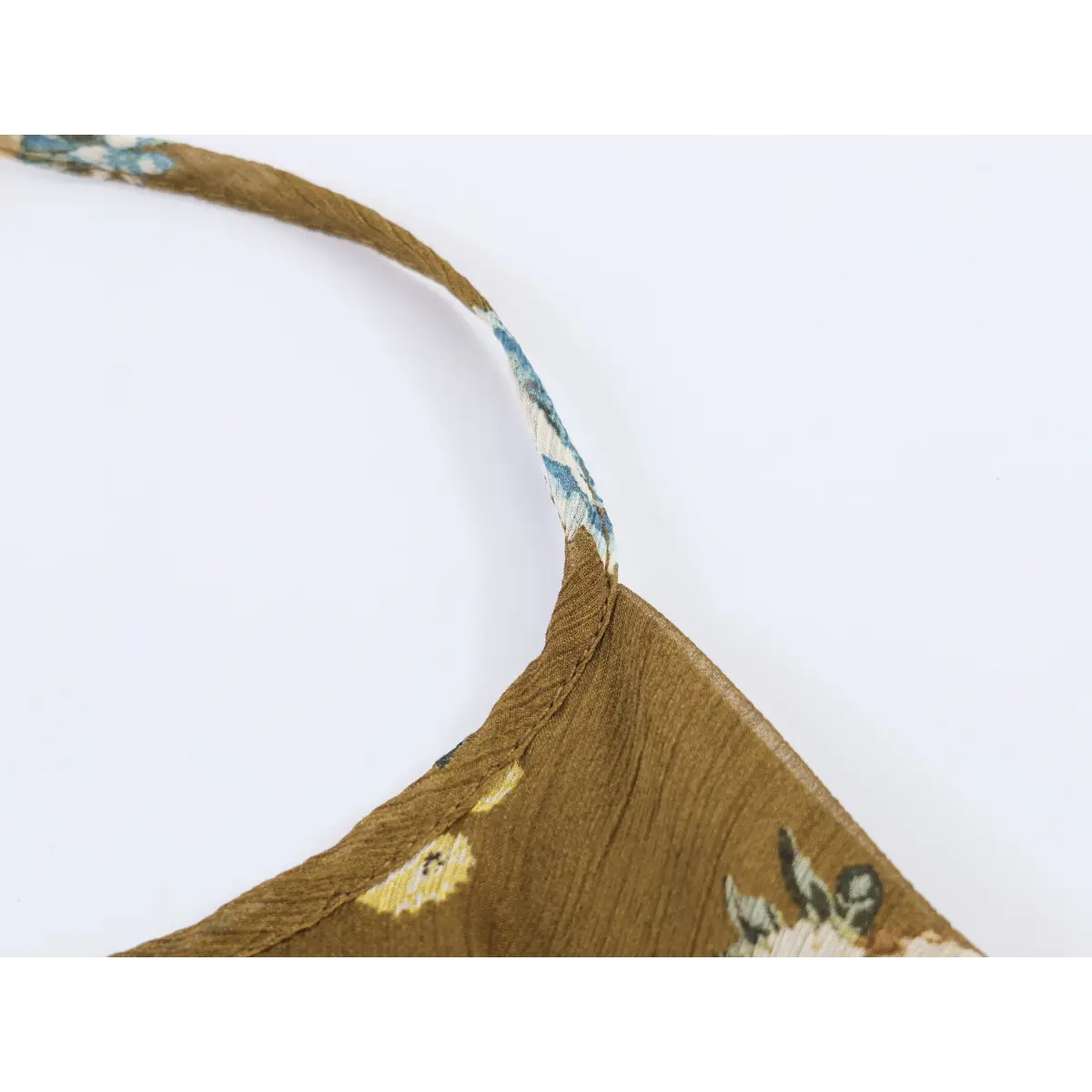 Close-up of narrow self-print halter neck strap and neat edge stitching for tiered mini dress.