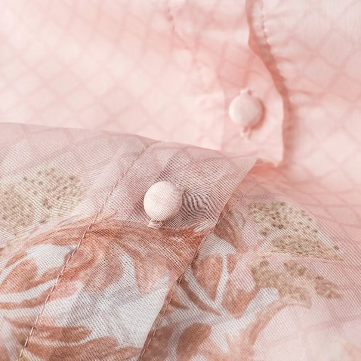 Close-up of fabric covered round button on vintage floral chiffon maxi dress