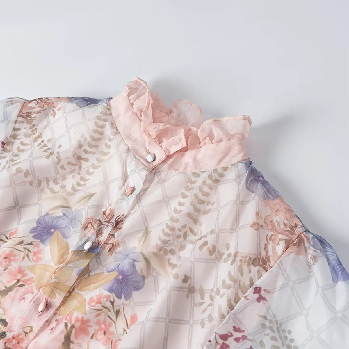 Close-up of ruffle stand collar on floral chiffon maxi dress, grid texture fabric with flower and bird print, front button placket