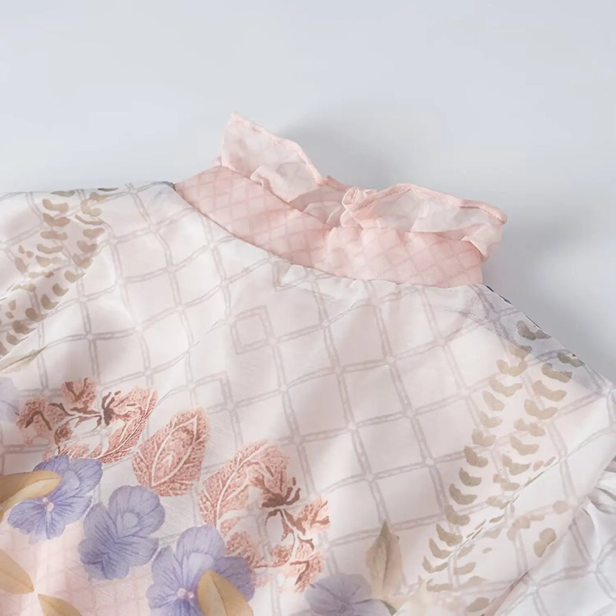 Close-up of ruffle high neck fabric of floral bird print maxi dress, grid sheer chiffon with vintage flower pattern