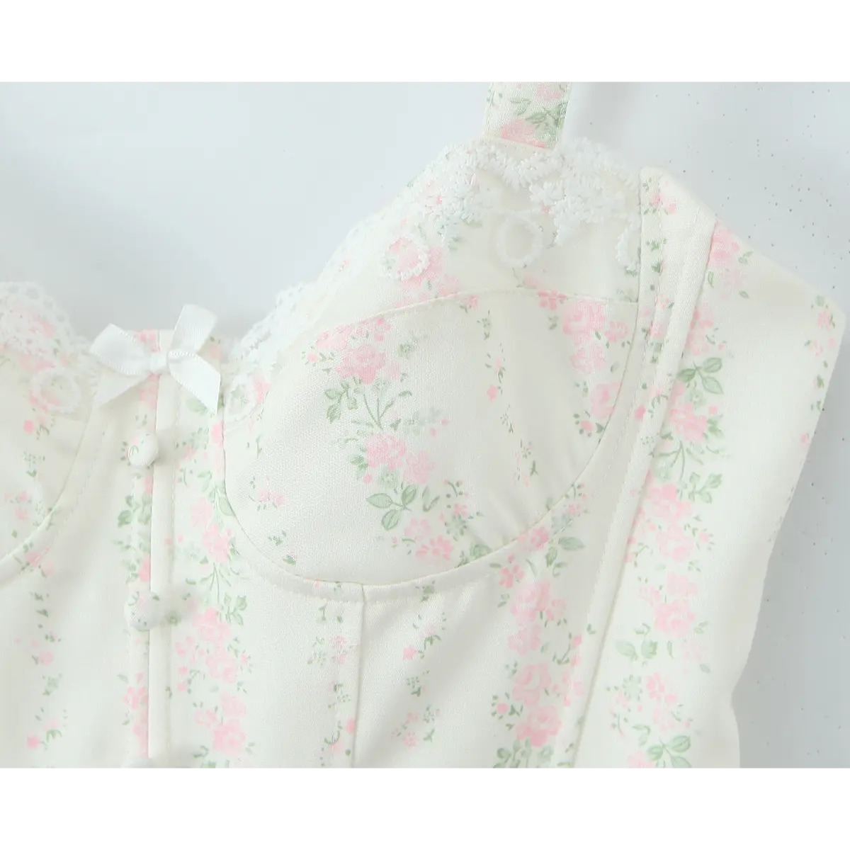 Close-up of the sweetheart bodice, lace trim, and center bow detail on the floral bustier.
