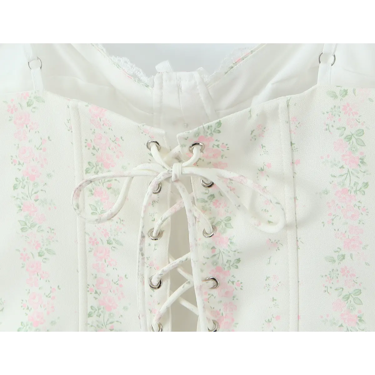 Close-up of the front lace-up closure with matching floral ribbon on the white bustier.