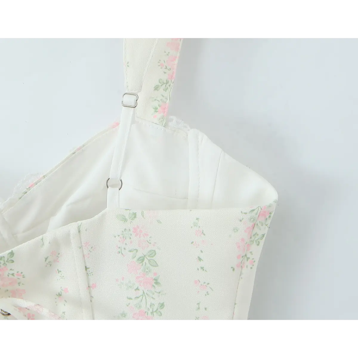 Close-up of the adjustable metal slider on the wide floral strap.
