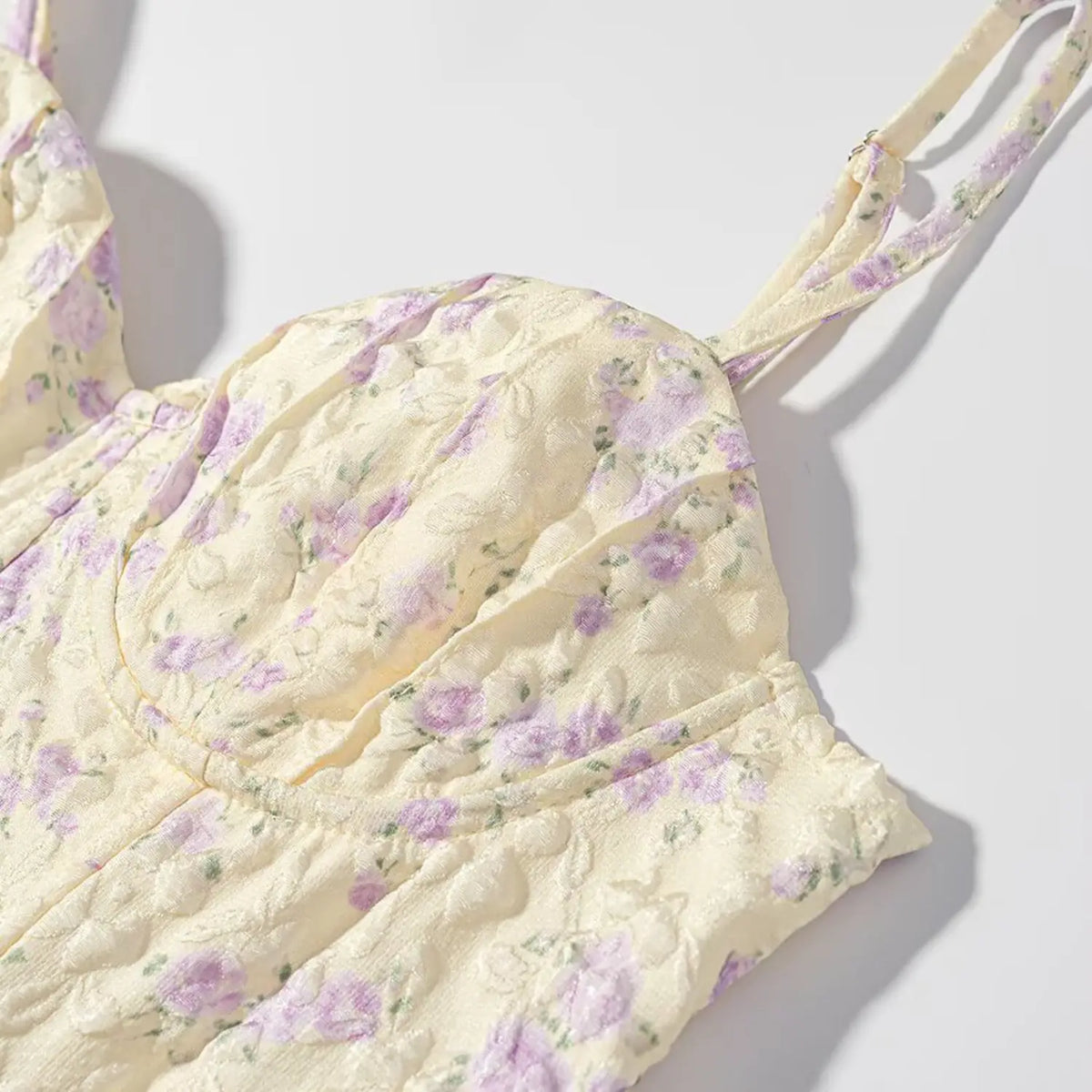 Close up of pale yellow purple floral corset top bust part, textured jacquard fabric, sweetheart cup, adjustable printed spaghetti strap