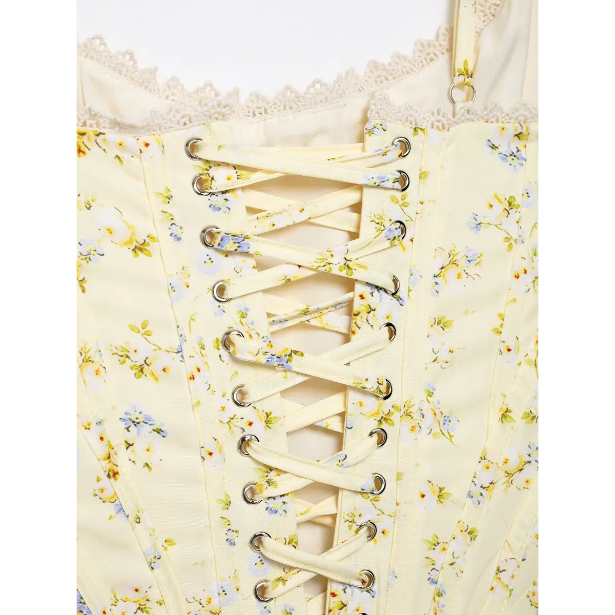Detailed shot of lace-up stitching on the back of pale yellow floral corset top.