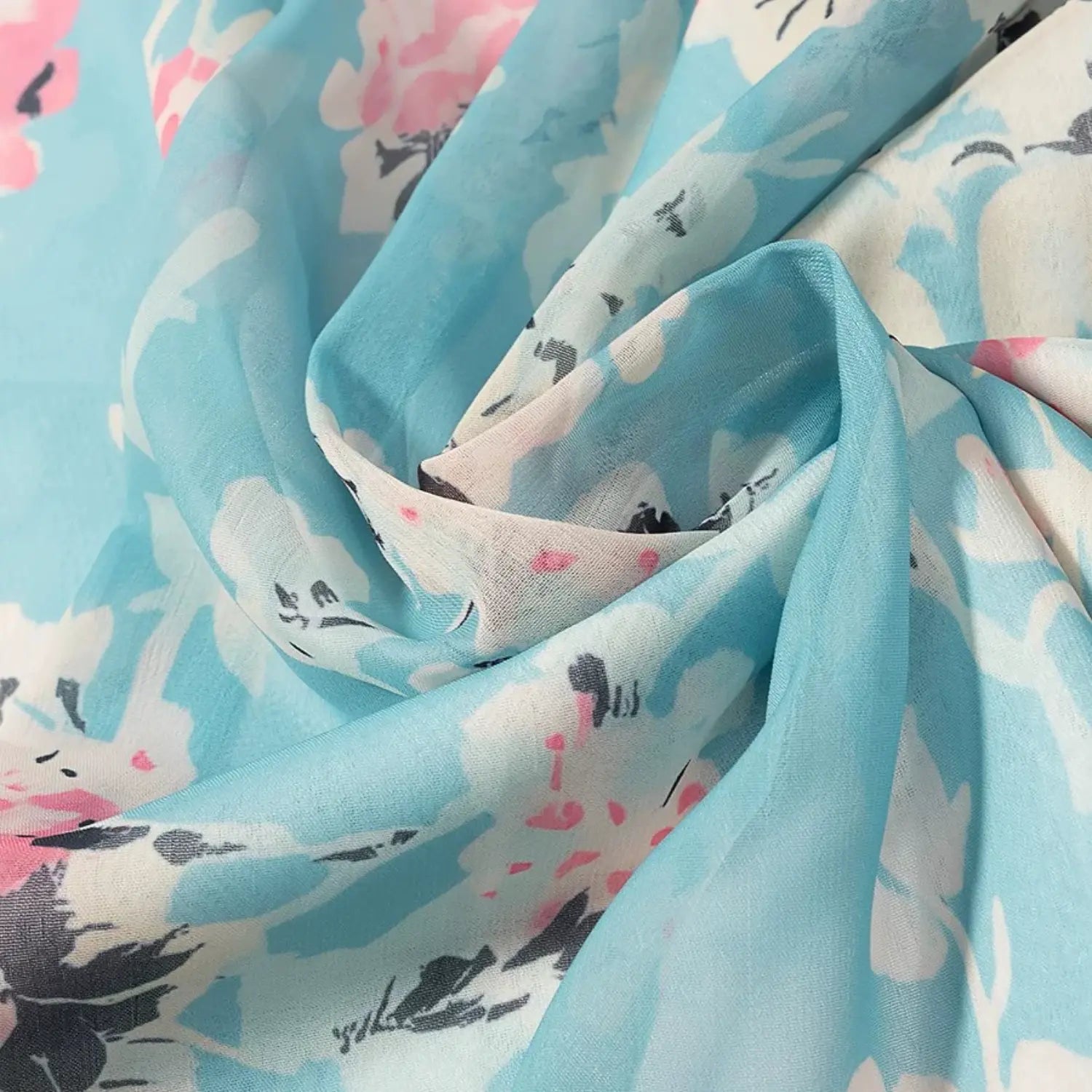 Extreme close‑up of crinkle chiffon texture, soft folds of blue watercolor floral print fabric