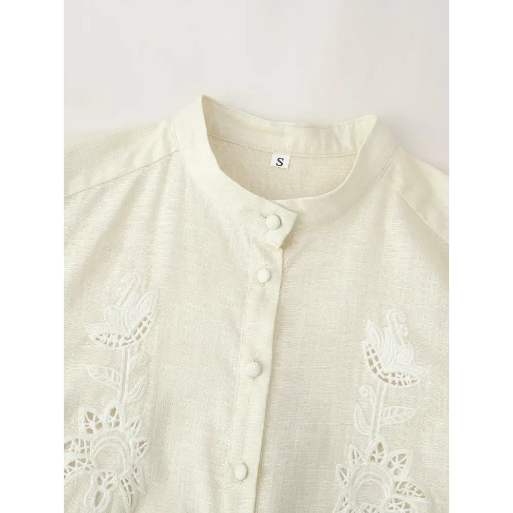 Close-up of stand collar, covered buttons and floral cutwork
