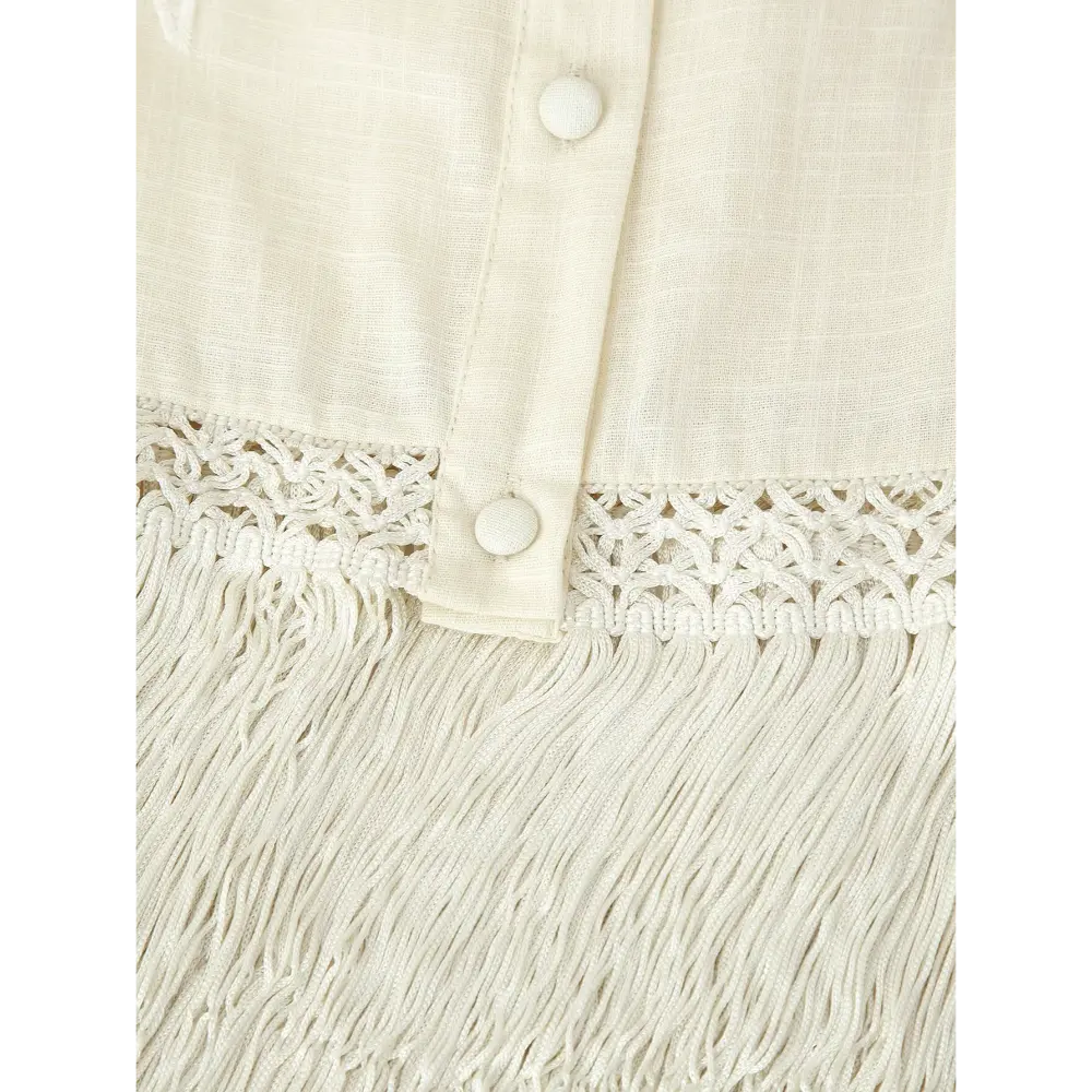 Close-up of crocheted lace trim and long fringe tassels