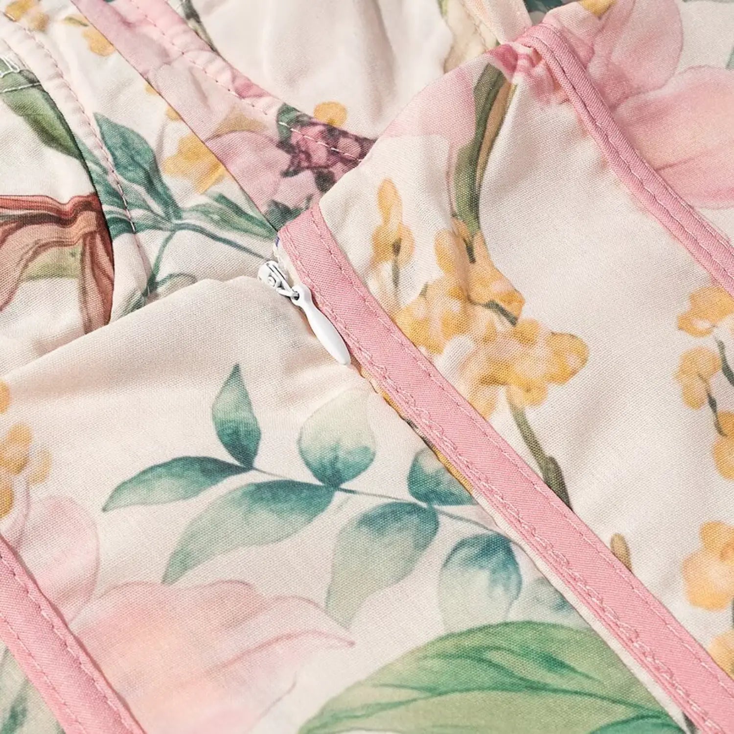 Bust front partial close-up, small white invisible zipper, pink contrast piping trim, mixed peony floral print fabric
