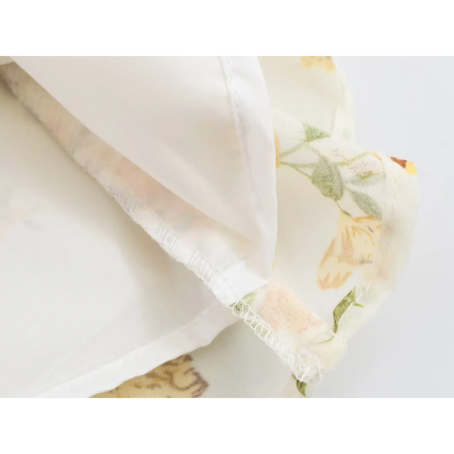Close-up of dress hem stitching and inner lining of yellow floral chiffon garment