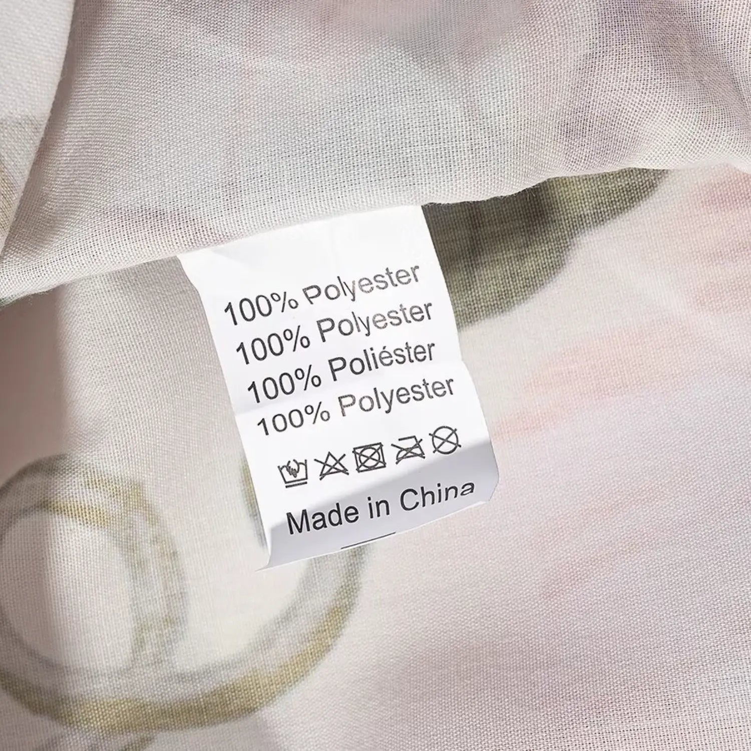Inner garment care tag close-up, 100% polyester fabric composition label, washing symbols printed on white tag