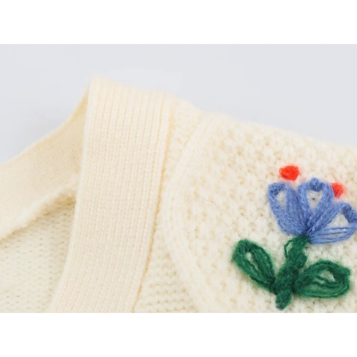 Close-up of ribbed placket and blue tulip embroidery