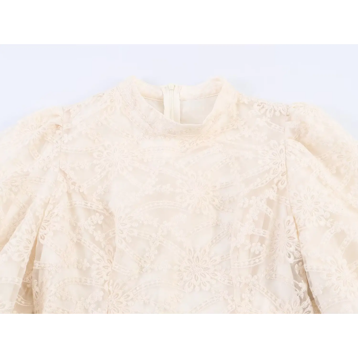 Close-up of high neck collar and back zipper on beige floral embroidered mini dress, intricate lace pattern