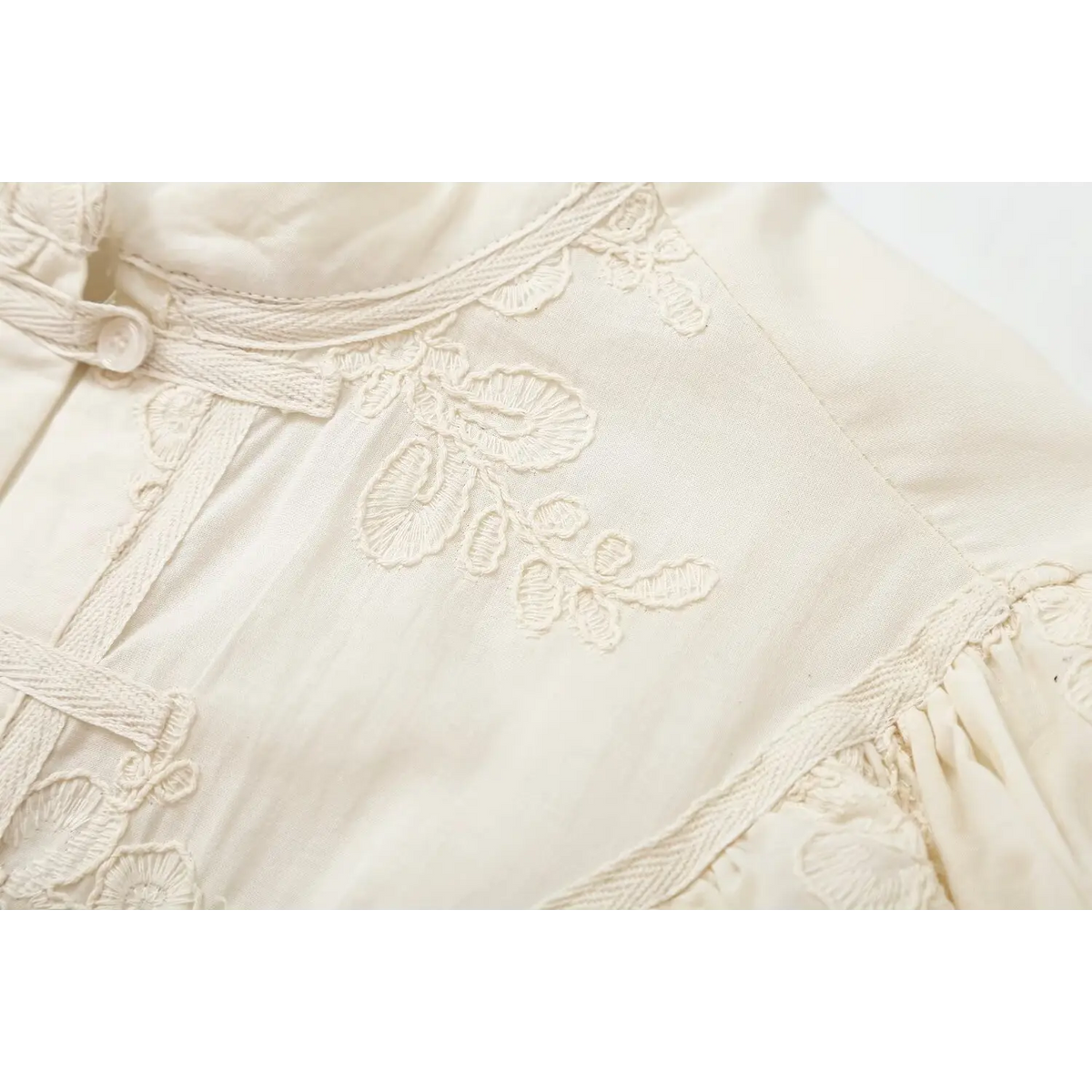 Close-up of shoulder embroidery and piping detail