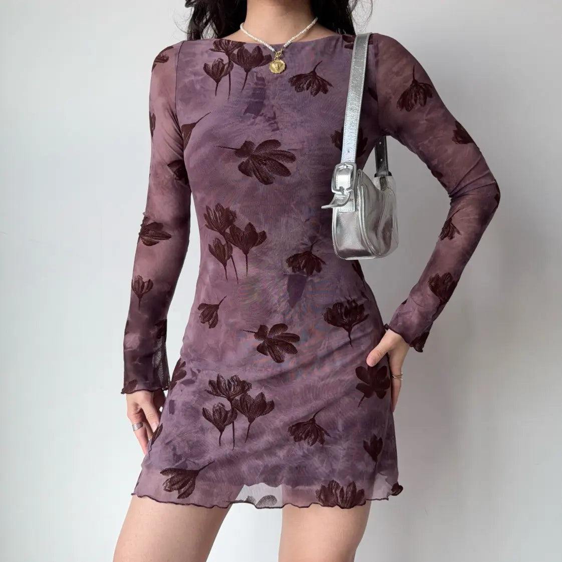 Model wearing floral flocked boat neck long sleeve bodycon mini dress with silver shoulder bag, front view