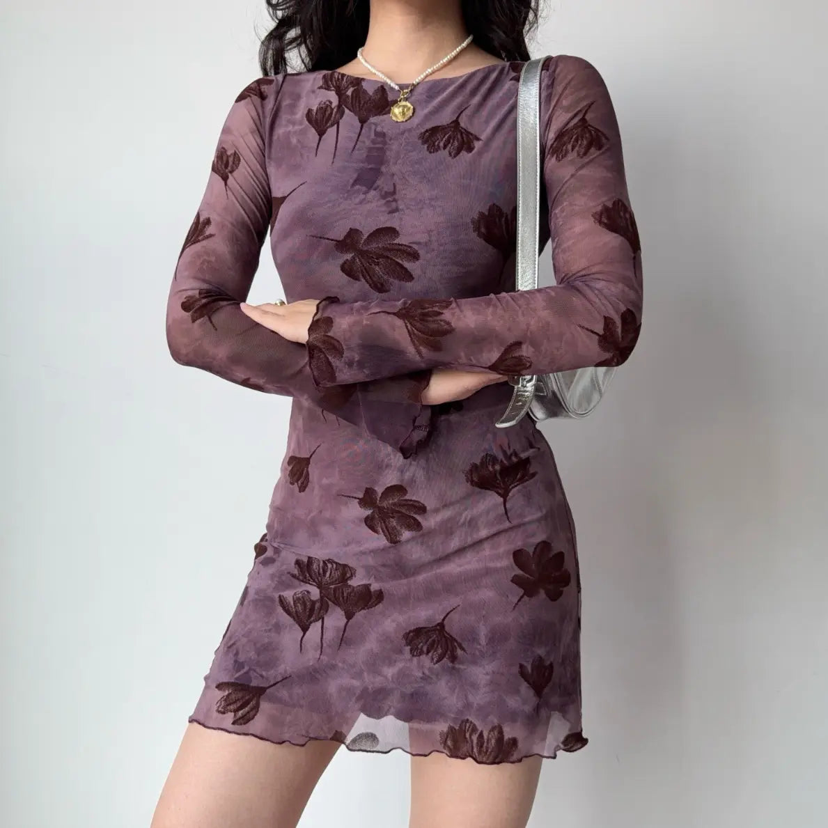 Model wearing floral flocked boat neck long sleeve bodycon mini dress, arms crossed view