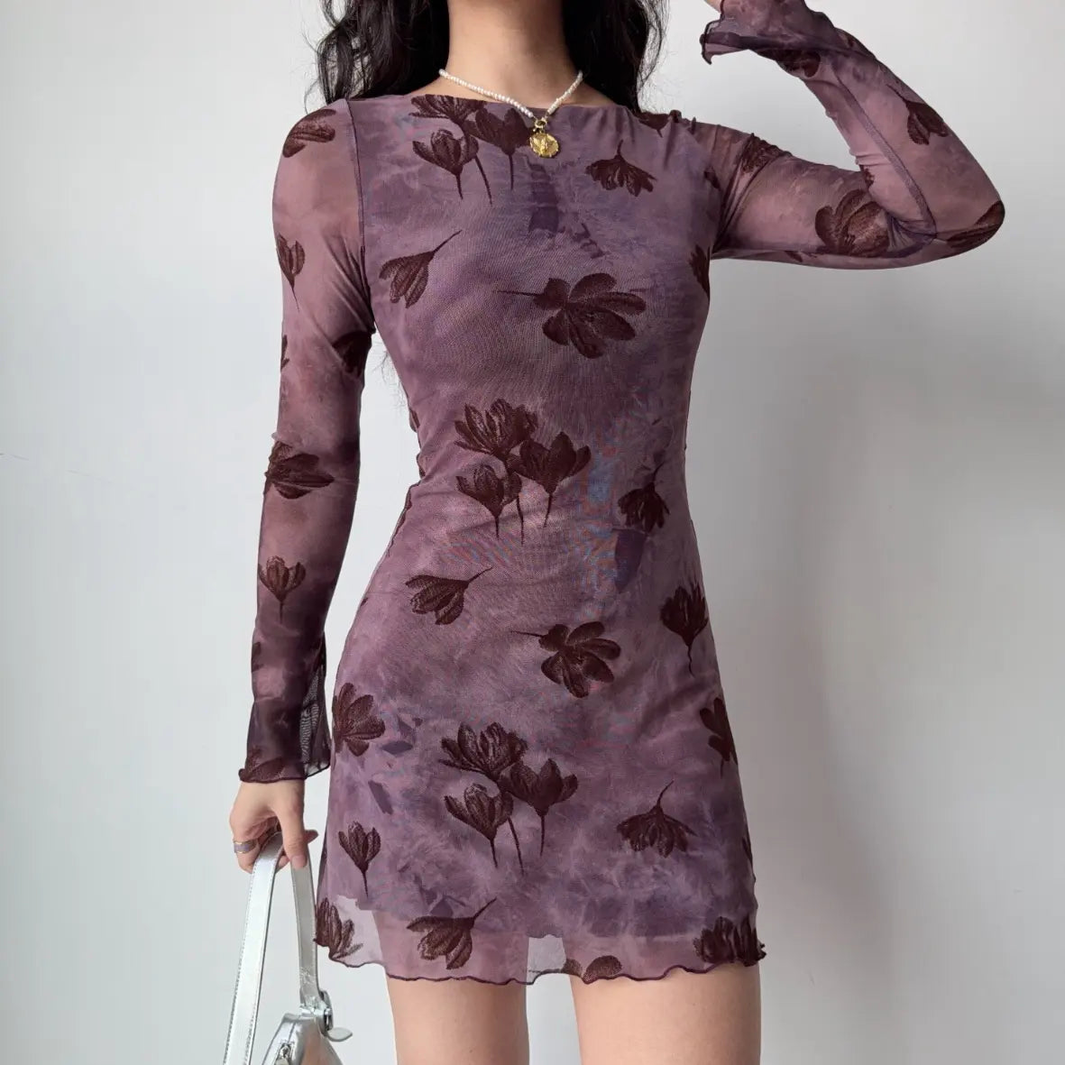 Model wearing floral flocked boat neck long sleeve bodycon mini dress, side angle view