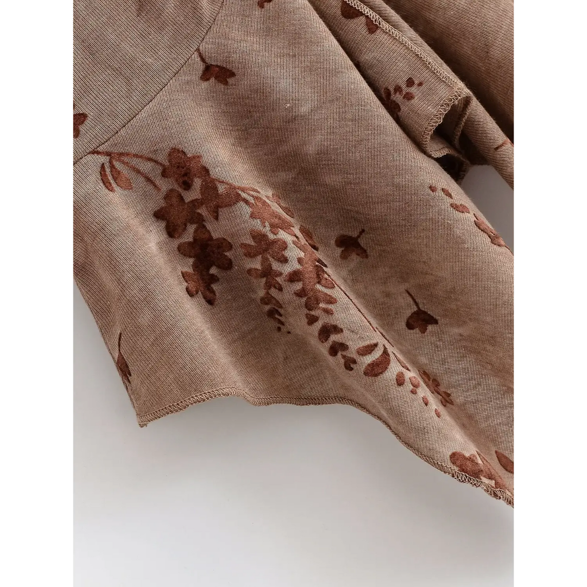 Close-up of hand-stitched hem edge and flocked floral