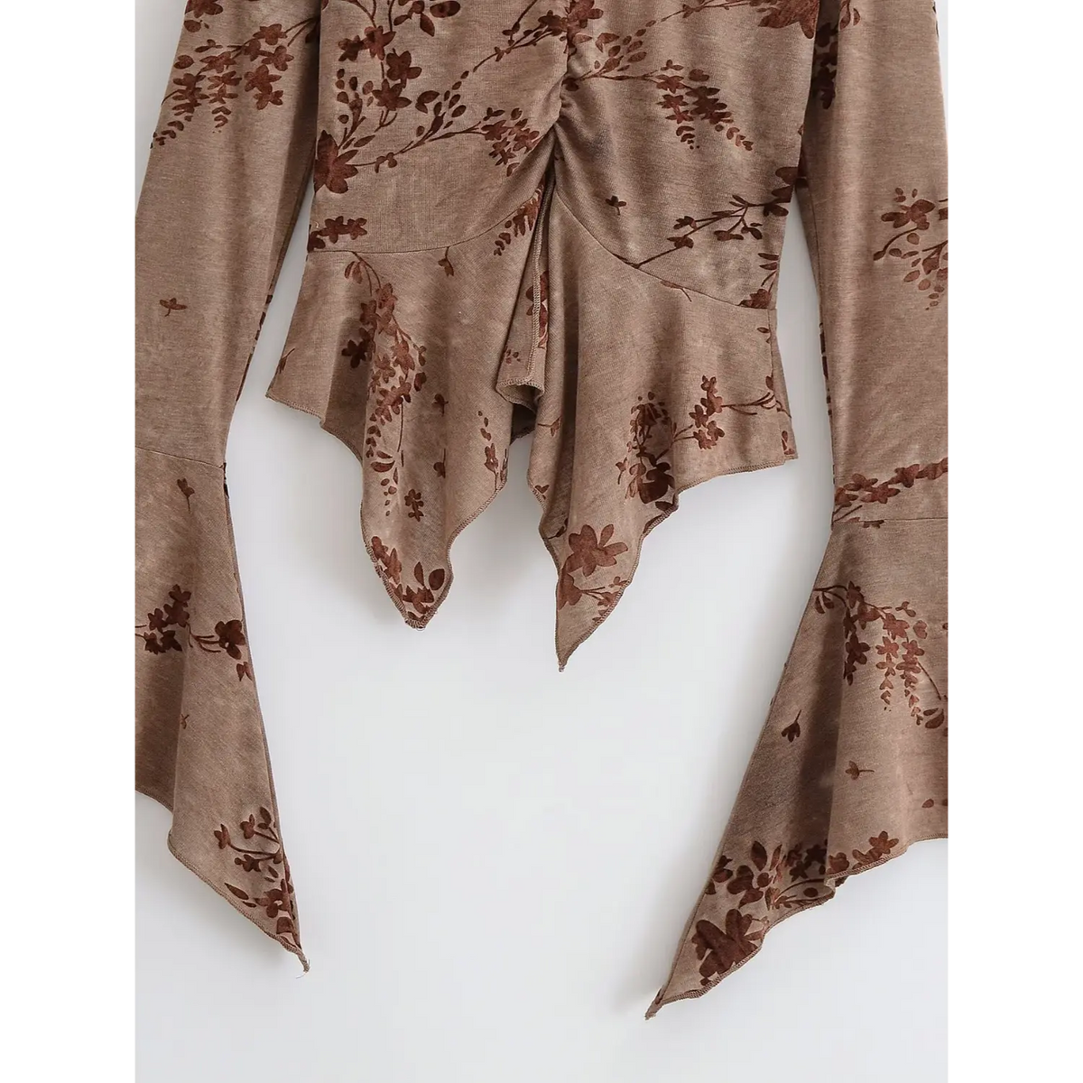 Close-up of asymmetric handkerchief hem and bell cuffs