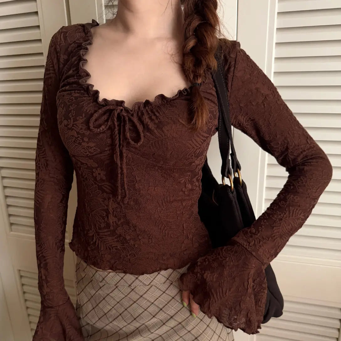 Model wearing brown floral jacquard ruffle tie neck bell sleeve crop top by door