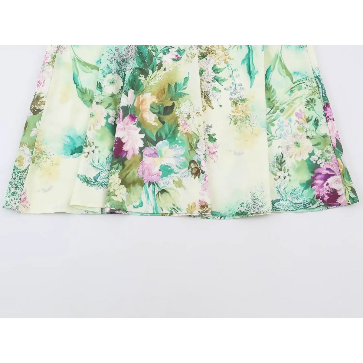 Close-up of softly gathered floral print fabric in cream, pink and green tones