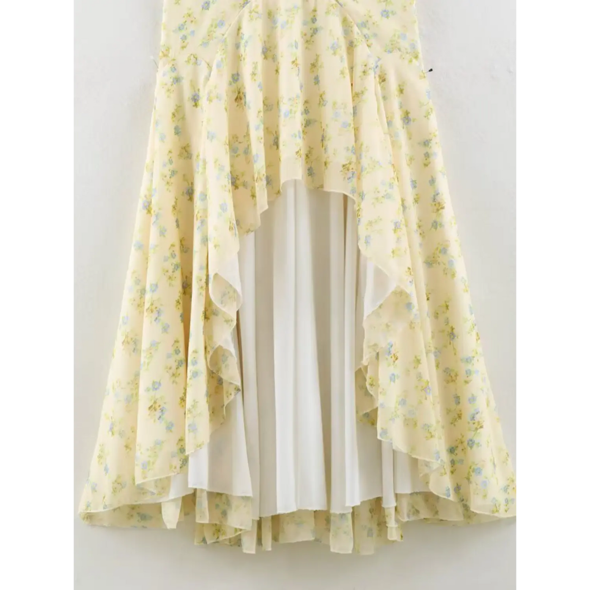 Full view of the maxi dress skirt, irregular layered ruffle hem, outer floral chiffon layer and solid white inner lining