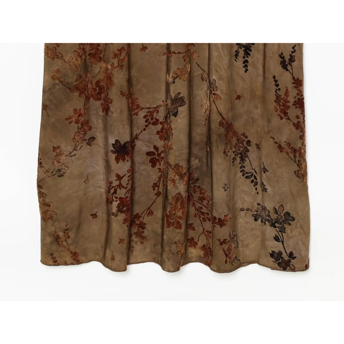 Partial view of sheer layered skirt and soft folds on brown floral chiffon maxi dress