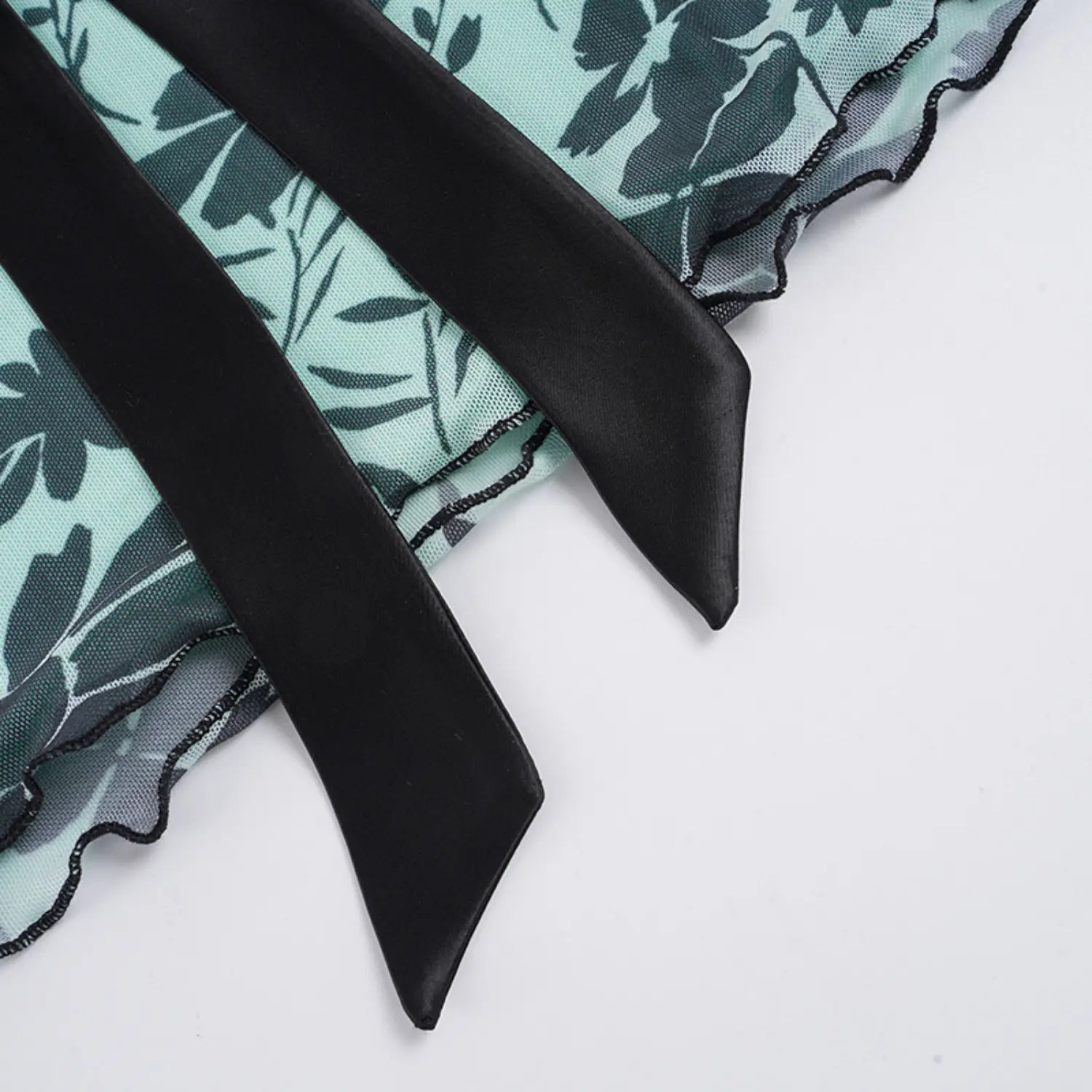 Close detail of tube top hem and satin ties, two pointed long black satin ribbon straps, wavy elastic overlock stitching on sheer mesh scalloped hem edge