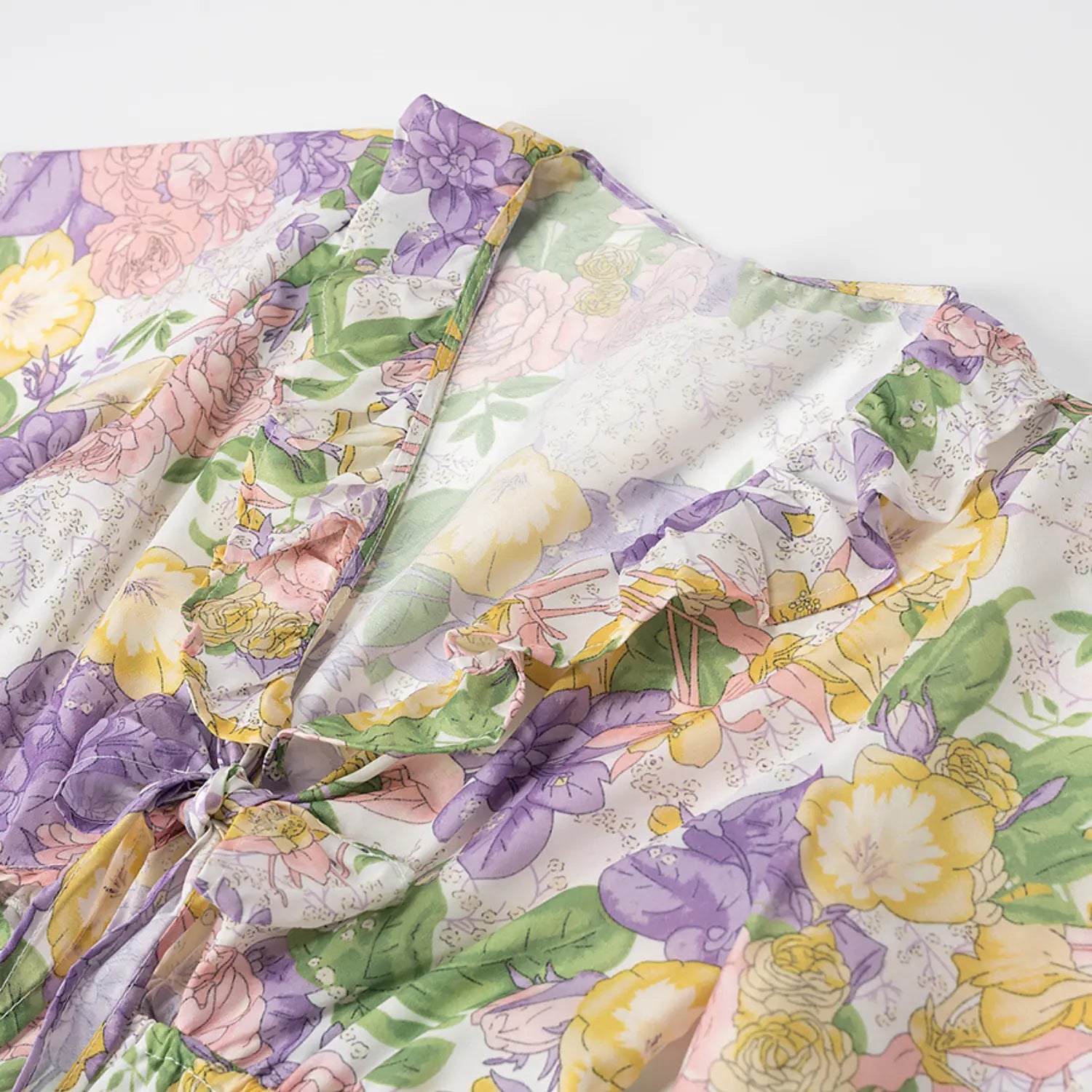 Front bust detail of v-neck ruffled floral dress with self fabric tie cutout design