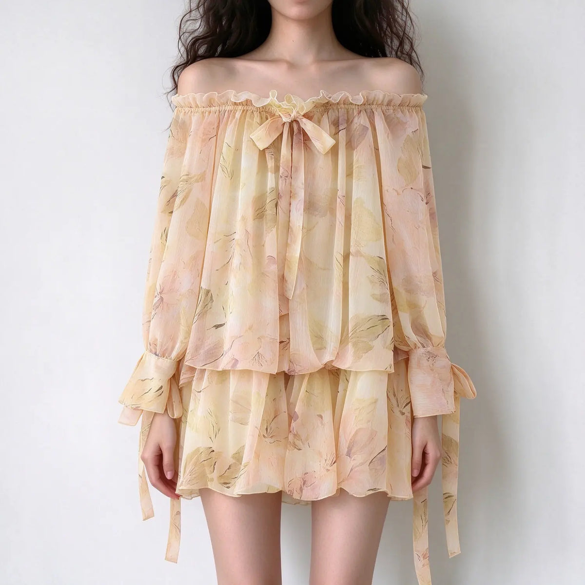 Model wearing floral off shoulder tiered mini dress, front view