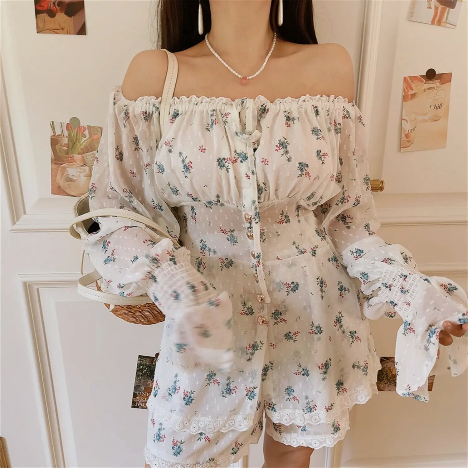 Side standing model view off shoulder floral coord set, elastic ruffle neckline, cinched smocked waist, flowy lace hem shorts, woven straw bag matching vacation style