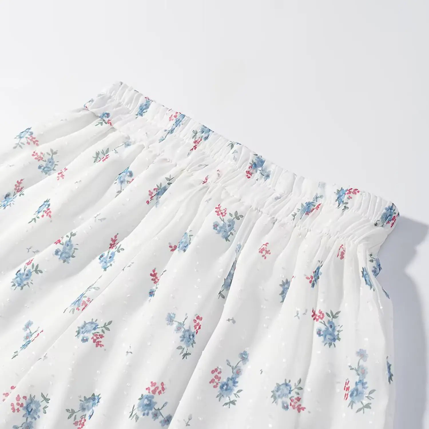 Full waistband overview matching floral shorts, full stretch elastic shirred waist, evenly distributed blue floral print, crinkle swiss dot surface