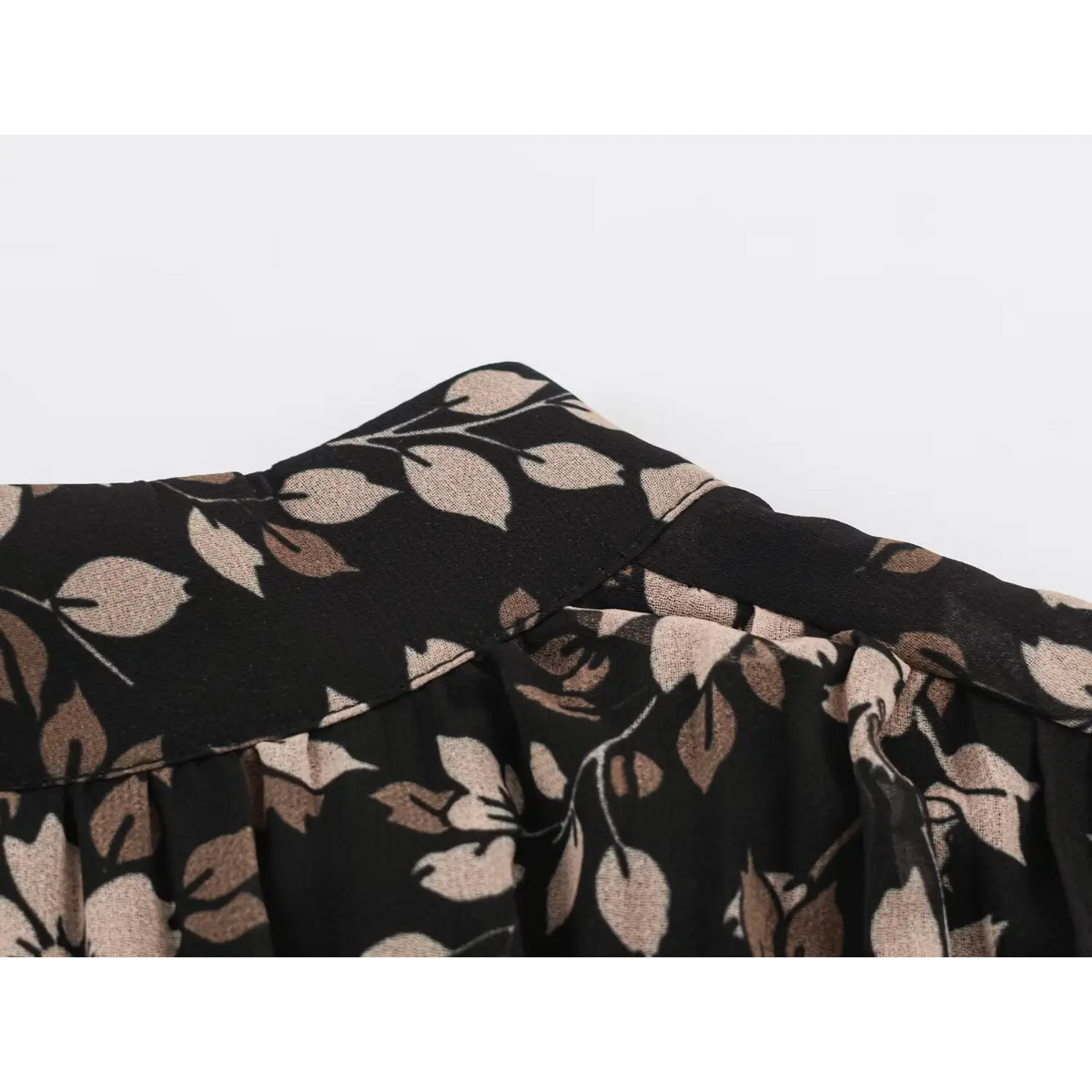 Close-up of black floral fabric with cream and brown foliage print