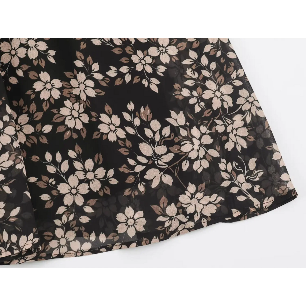 Close-up of vintage floral print with cream flowers and brown foliage on black fabric