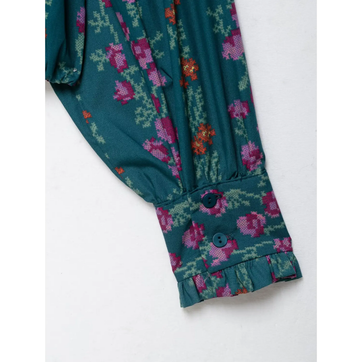 Close-up of cuff buttons and ruffle trim
