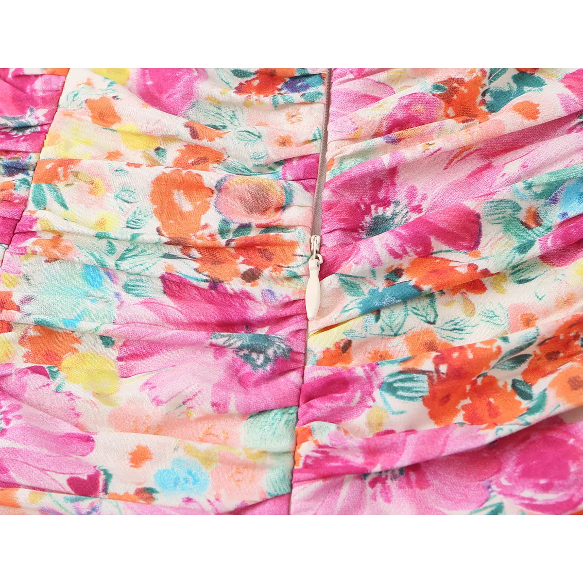 Close-up of the dress's center back zipper with a white pull tab, set against the floral print.