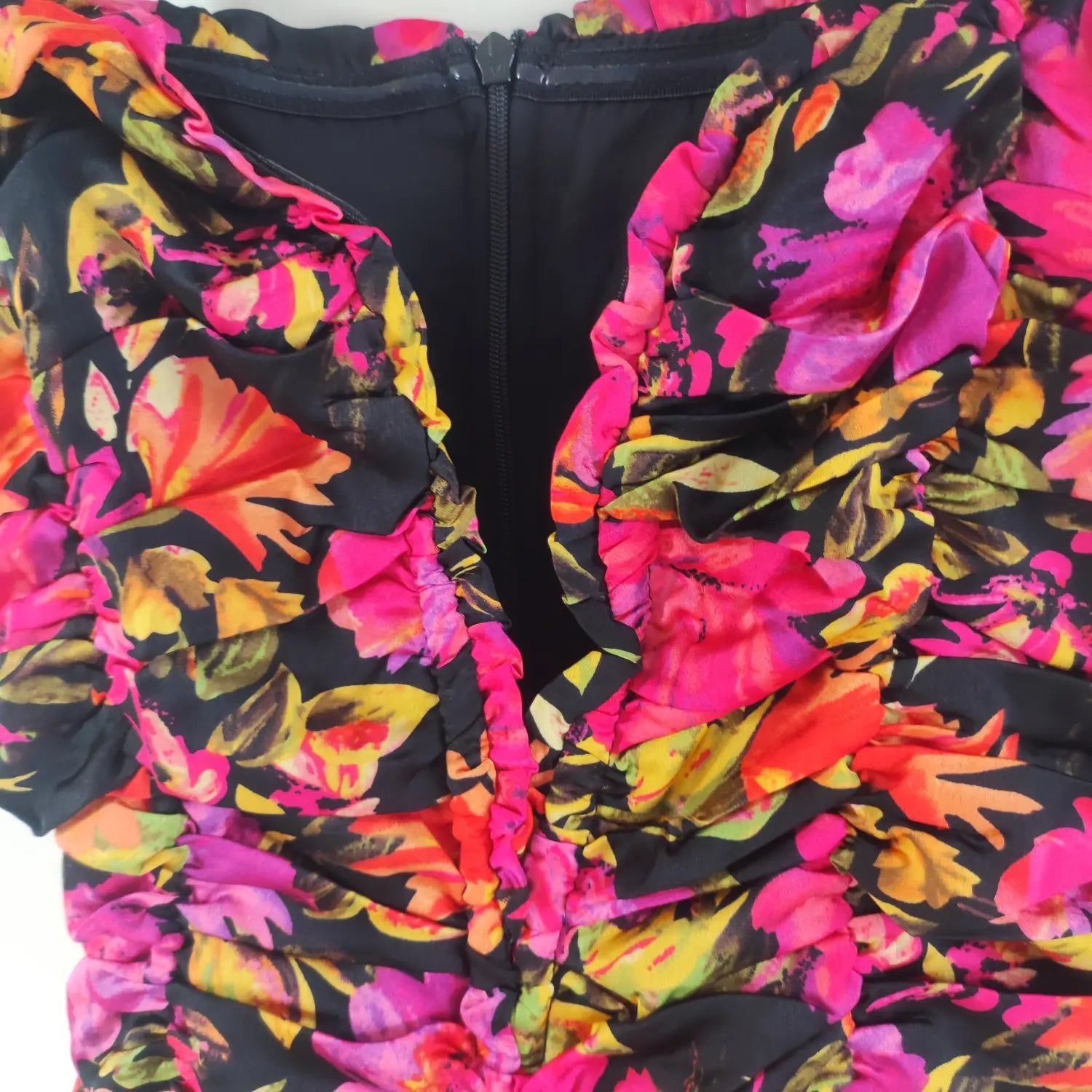 Close‑up front bodice ruffle and center zipper detail bright floral ruched cami dress