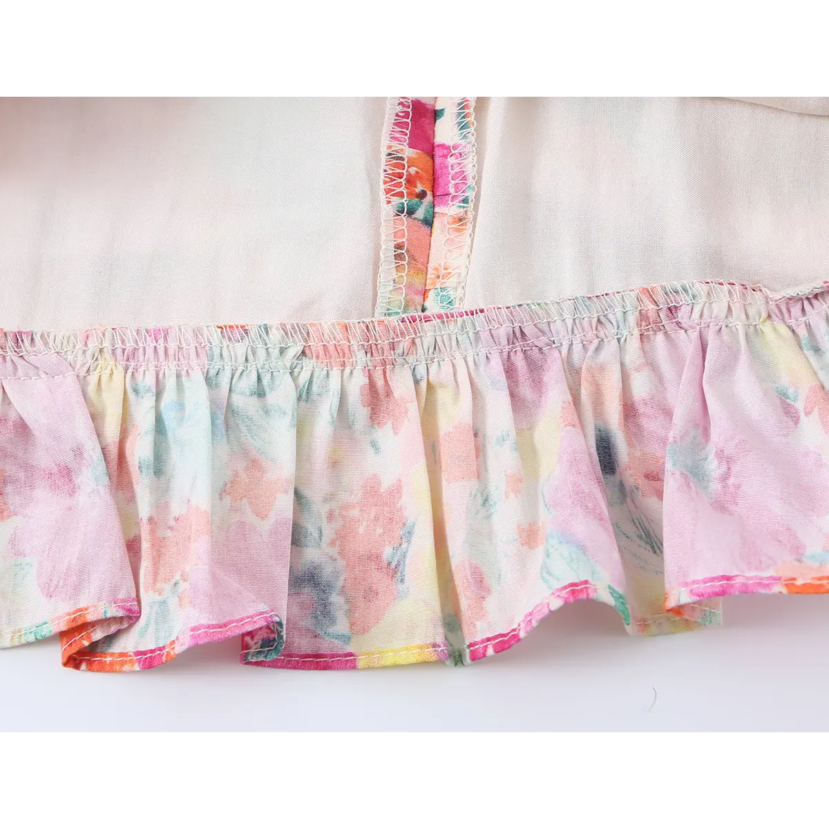 Close-up of the dress's hem, featuring a gathered ruffle and visible seam stitching.